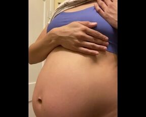 Rubbing my growing pregnant belly and nipples